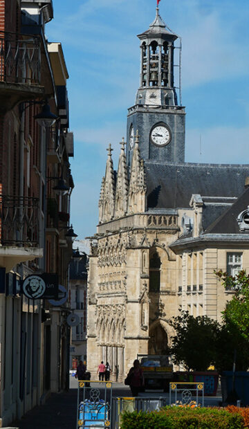 Perspective d’une rue animée bordée de magasins avec vue sur l'Hôtel de ville