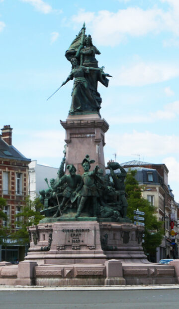 Vue large de la place du 8 octobre avec passants et vitrines