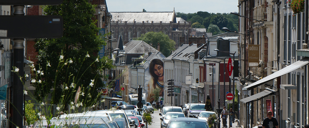 Scène urbaine sur la rue Émile Zola à Saint-Quentin, entre shopping et flânerie